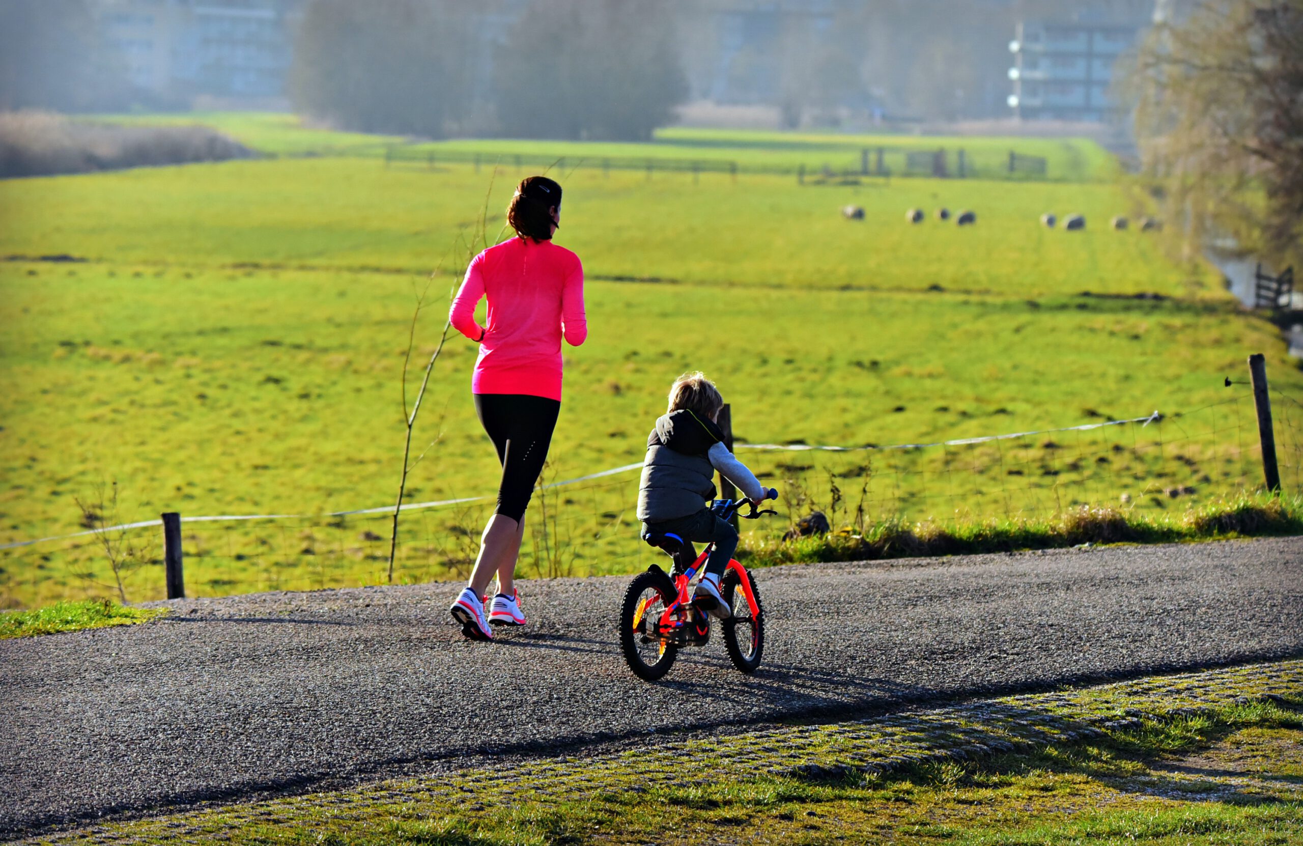 Madre haciendo footing mientras su hijo va en bicicleta
